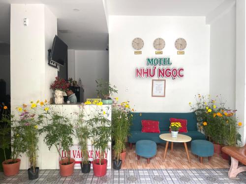 a room with a blue couch and potted plants at Như Ngọc Motel in Cà Mau