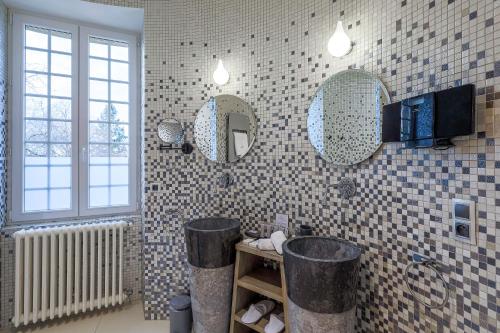 a bathroom with three mirrors and a sink in it at Château de Maraval in Cénac-et-Saint-Julien