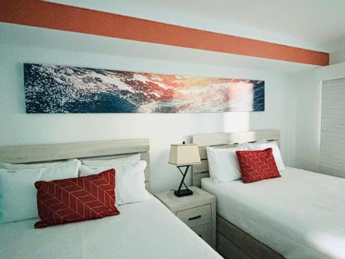 two beds with red pillows in a bedroom at 453 Shore Fun Oceanfront Great Location in Myrtle Beach