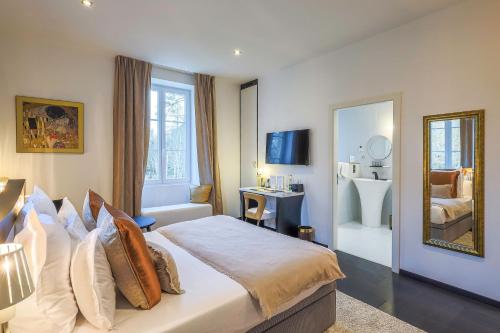 a hotel room with a bed and a mirror at Château de Maraval in Cénac-et-Saint-Julien