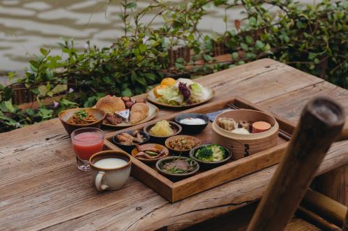 un plateau avec des assiettes de nourriture sur une table en bois dans l'établissement Somland Resort, à Paiya