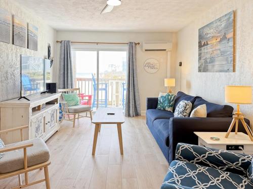 een woonkamer met een blauwe bank en een tv bij Out To Sea - Oceanfront 2 Bedroom, 2 Bath Condo in North Topsail Beach