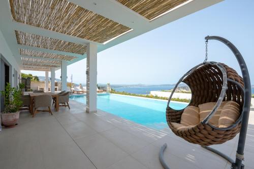 a porch with a swing and a swimming pool at Lamar Private Luxury Villas in Marathias