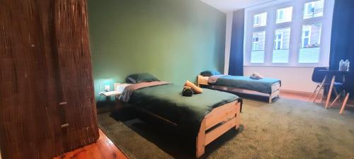 Habitación con 2 camas, sofá y ventana en Stacja Jeżyce, en Poznan