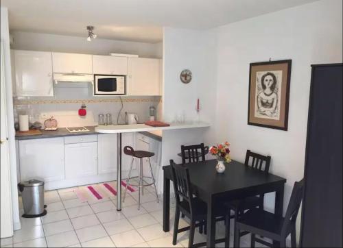 une cuisine et une salle à manger avec une table et des chaises dans l'établissement Appartement Le Port du Suquet, à Cannes