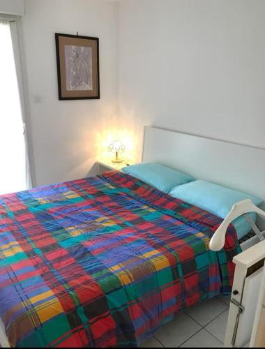 - une chambre avec un lit et une couverture colorée dans l'établissement Appartement Le Port du Suquet, à Cannes