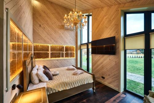 a bedroom with a bed and a chandelier at Сімейний Екопарк Ясногородка in Yasnogorodka