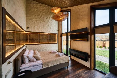 a bedroom with a bed in a room with windows at Сімейний Екопарк Ясногородка in Yasnogorodka