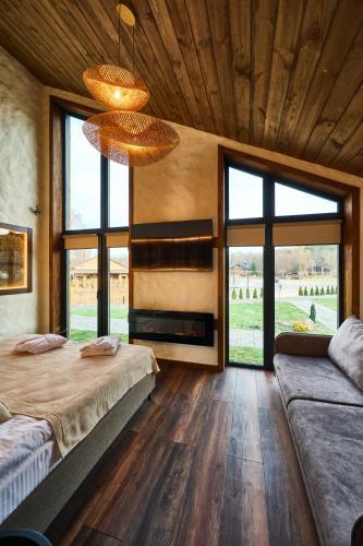a bedroom with two beds and large windows at Сімейний Екопарк Ясногородка in Yasnogorodka