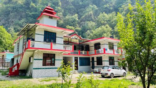 a house with a car parked in front of it at Mountain River Homestay in Sainj