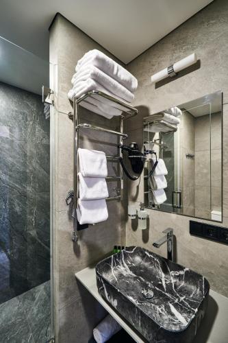 a bathroom with a sink and a mirror and towels at Сімейний Екопарк Ясногородка in Yasnogorodka