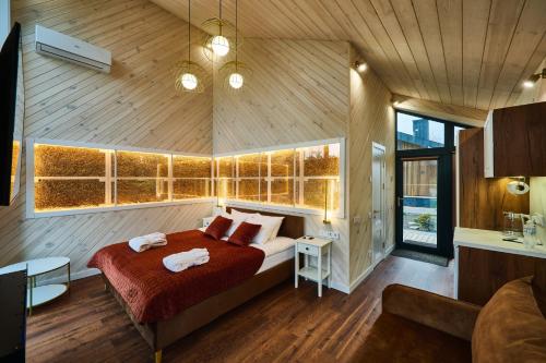 a bedroom with a bed in a room with wooden walls at Сімейний Екопарк Ясногородка in Yasnogorodka