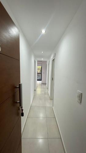 a hallway with white walls and a door and a hallwayngth at La Barracuda in Pinamar