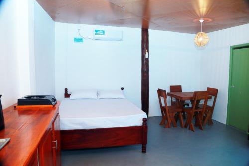 a bedroom with a bed and a desk and a table at Holiday Beach Cottage in Ahangama