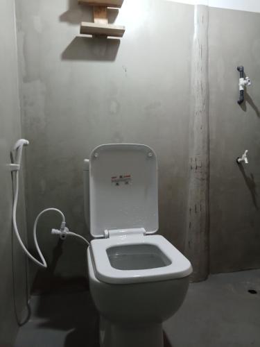a bathroom with a toilet in a room at Holiday Beach Cottage in Ahangama