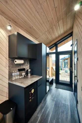 a kitchen with black cabinets and a large window at Сімейний Екопарк Ясногородка in Yasnogorodka