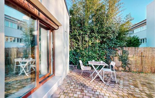un patio avec une table et des chaises à côté d'un bâtiment dans l'établissement Lovely Apartment In Schiltigheim, à Schiltigheim