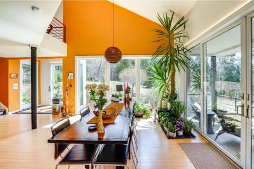 a dining room with orange walls and a table and chairs at Cozy Mountain Home in the Catskills - Fall Views & Trails in Elka Park