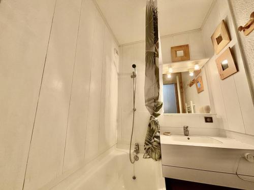 une salle de bain blanche avec une baignoire et un lavabo dans l'établissement Appartement cosy 4 pers, proche pistes, balcon, parking - FR-1-353-61, à La Plagne