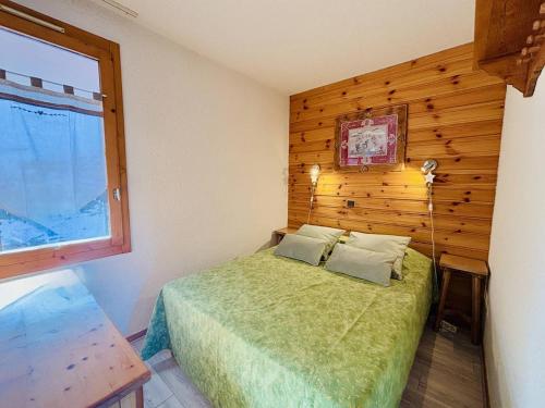 - une chambre avec un lit et un mur en bois dans l'établissement Appartement cosy 4 pers, proche pistes, balcon, parking - FR-1-353-61, à La Plagne
