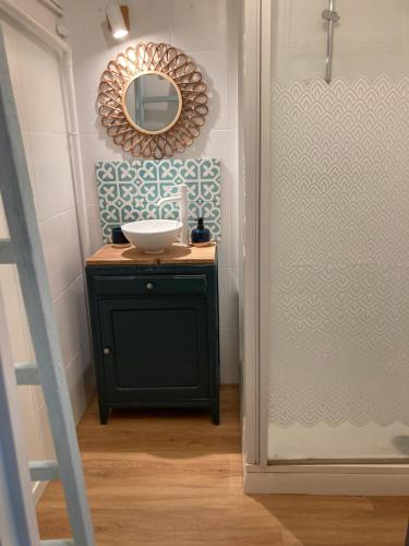 une salle de bain avec un lavabo et un miroir dans l'établissement Studio du vieux port, à Quiberon