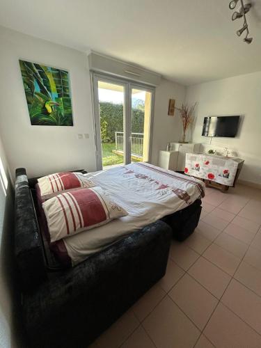 une chambre avec un grand lit dans une pièce dans l'établissement La Belle Échappée Pyrénéenne, à Lourdes