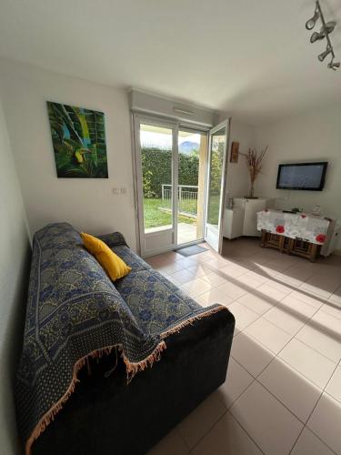 un salon avec un canapé et une télévision dans l'établissement La Belle Échappée Pyrénéenne, à Lourdes