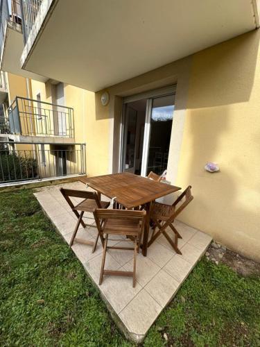 une table et des chaises en bois installées à côté d'un bâtiment dans l'établissement La Belle Échappée Pyrénéenne, à Lourdes