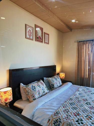 a bedroom with a bed with pillows and two lamps at Himalayan Hideaway in Shimla