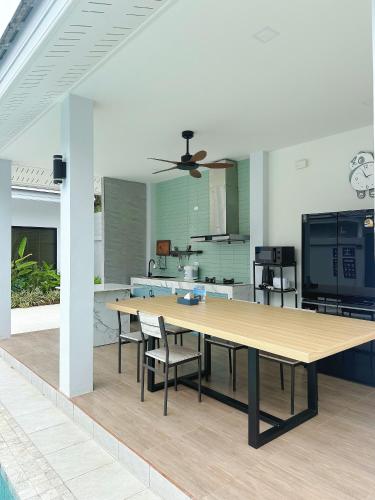 a kitchen with a large wooden table and chairs at Aonang nine poolvilla resort in Ao Nang