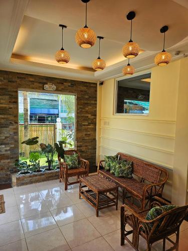 un portico con panche, tavolo e finestra di Adlaw Inn a Città di Puerto Princesa
