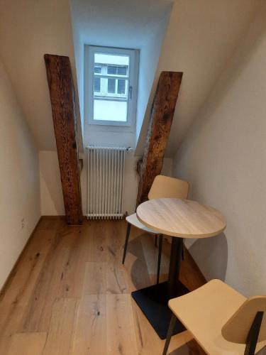 a small room with a table and a window at Apartments Greifengasse - Managed by Hotel Rheinfelderhof in Basel