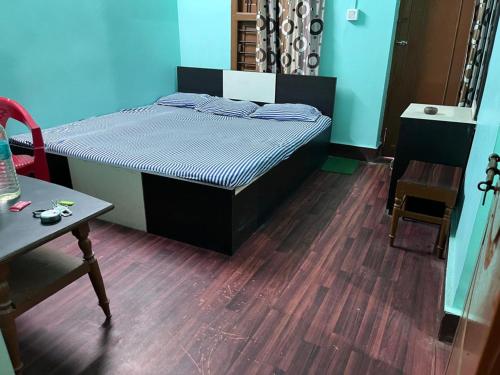 a bedroom with a bed and a wooden floor at Hotel Nandan in Digha