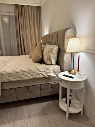 a bedroom with a bed and a table with a lamp at Boutique apartment in Ploieşti