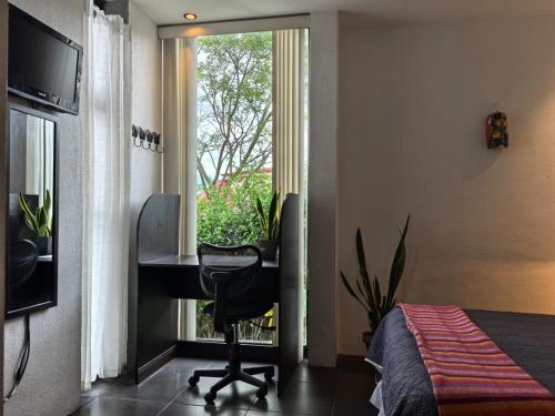 a bedroom with a desk and a desk and a window at Casa Marlui-San José in Curridabat