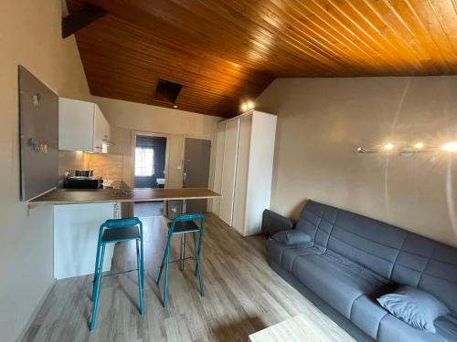 - un salon avec un canapé et deux tabourets bleus dans l'établissement Studio Périgueux 2ème étage, à Périgueux