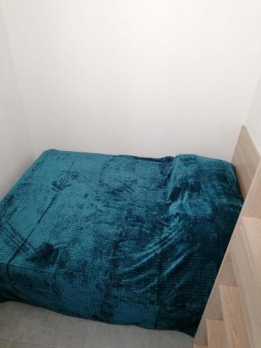 - un lit avec une couverture bleue au sol dans l'établissement Appartement vue mer 