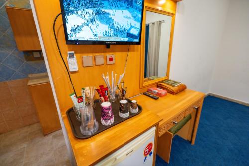 a room with a counter with a television and a desk with pens at فندق زاد المجد مكة الروضة in Makkah