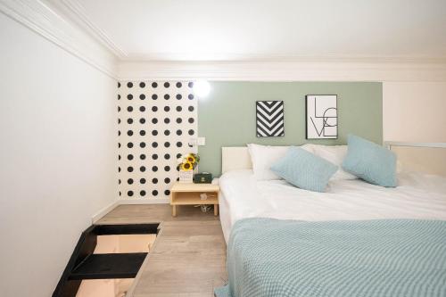a bedroom with a large white bed with blue pillows at 柃居 B&B - Jing'an Temple Branch in Shanghai