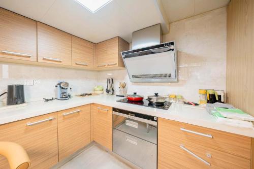 a kitchen with wooden cabinets and a stove top oven at 柃居 B&B - Jing'an Temple Branch in Shanghai