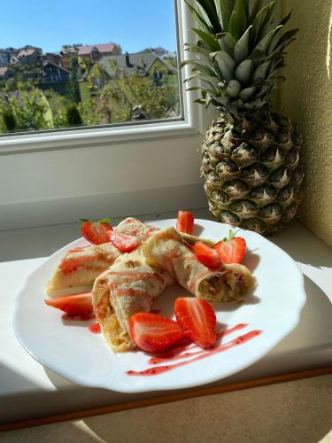een bord met aardbeien op een tafel met een ananas bij Вілла Рай in Skhidnitsa