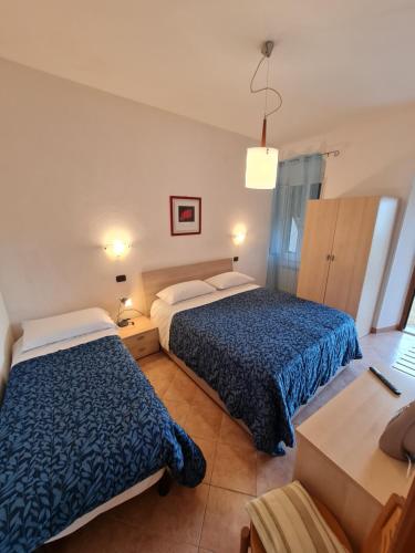 a hotel room with two beds and a desk at Albergo Genio in Portovenere