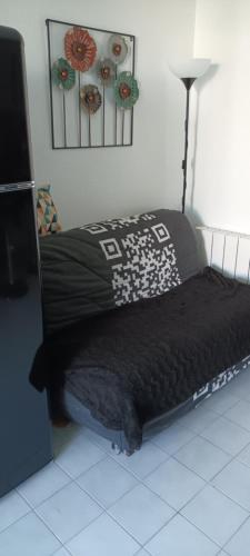 - une chambre avec un lit et une couette noire dans l'établissement Studio 26 M2 terrasse 6 M2 La Grande Motte, à La Grande Motte