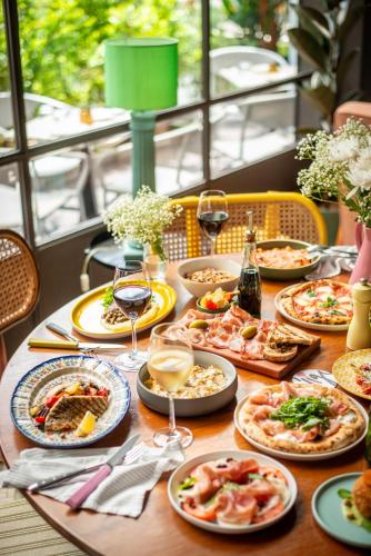 una tavola con piatti di cibo e bicchieri di vino di Uno Express a Bangkok