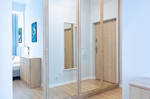 a large mirror in a room with a bedroom at Apartamenty Rondo in Świnoujście