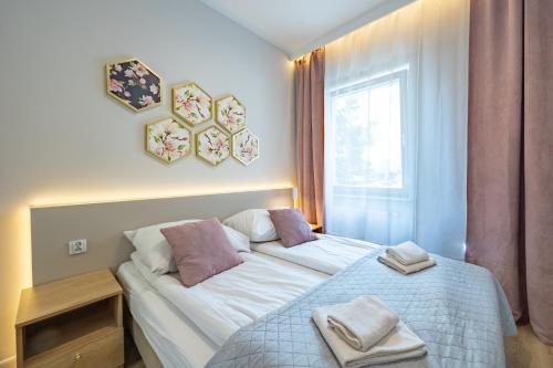 a bedroom with a bed with two towels on it at Apartamenty Rondo in Świnoujście