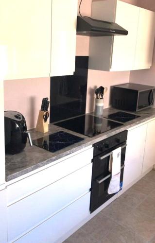 a kitchen with a stove and a counter top at Sowena Contractor Stays - Cleethorpes in Grimsby