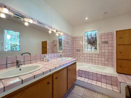 La salle de bains est pourvue de 2 lavabos, d'une baignoire et d'une chambre. dans l'établissement Villa La Mastineria, au Plan-de-la-Tour