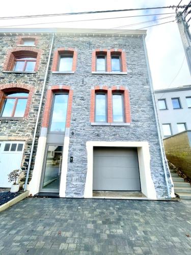 a brick building with two garage doors on it at Le Quartier Général des Amis in Bastogne