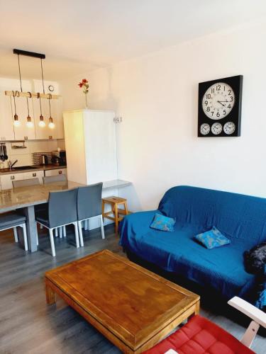 un salon avec un canapé bleu et une table dans l'établissement Cauterets et son bel appartement, à Cauterets